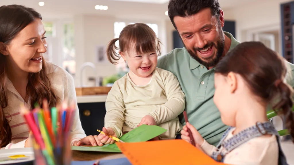 Family of parents and two young girls colouring