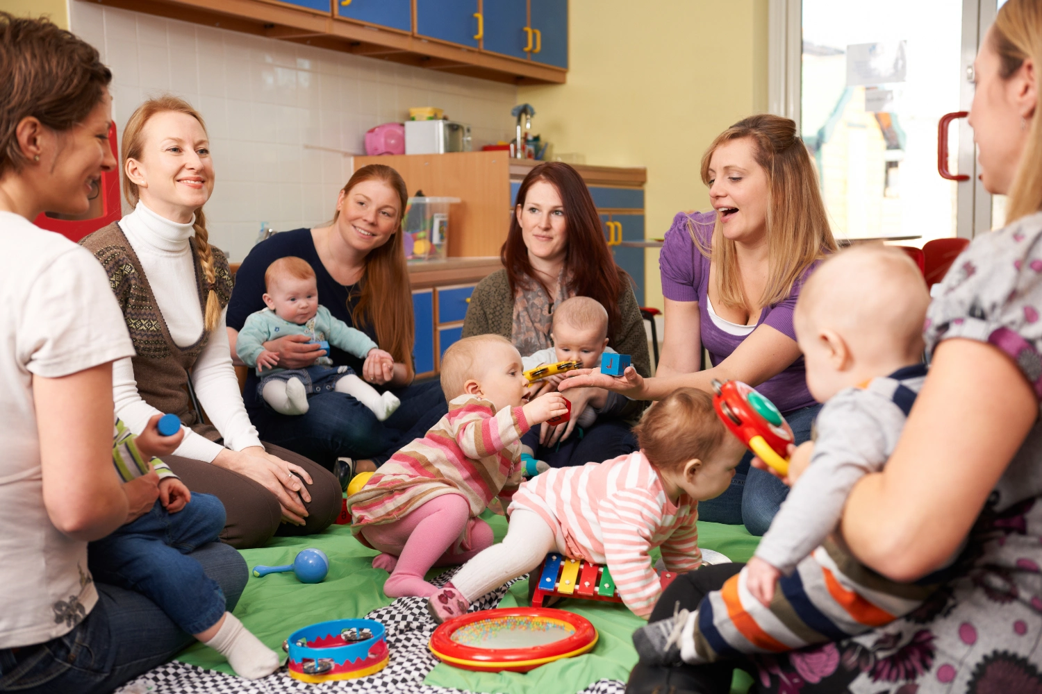 Group of parents/carers playing with young babies and children