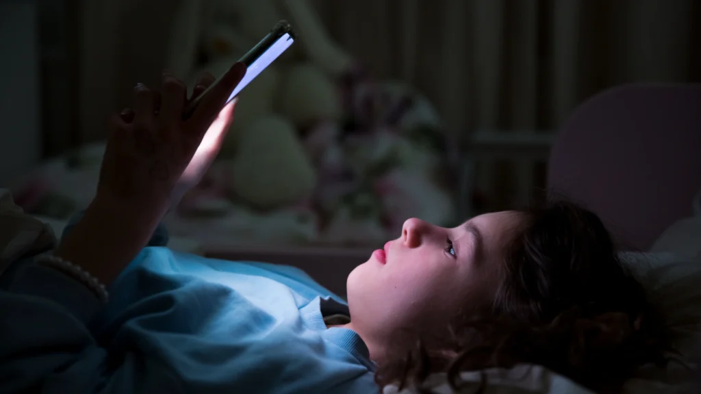 Young boy on his phone in the dark