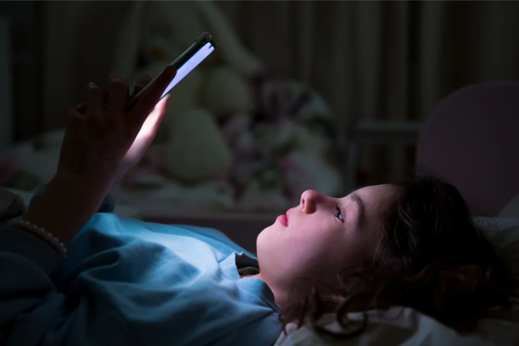 Young boy on his phone in the dark