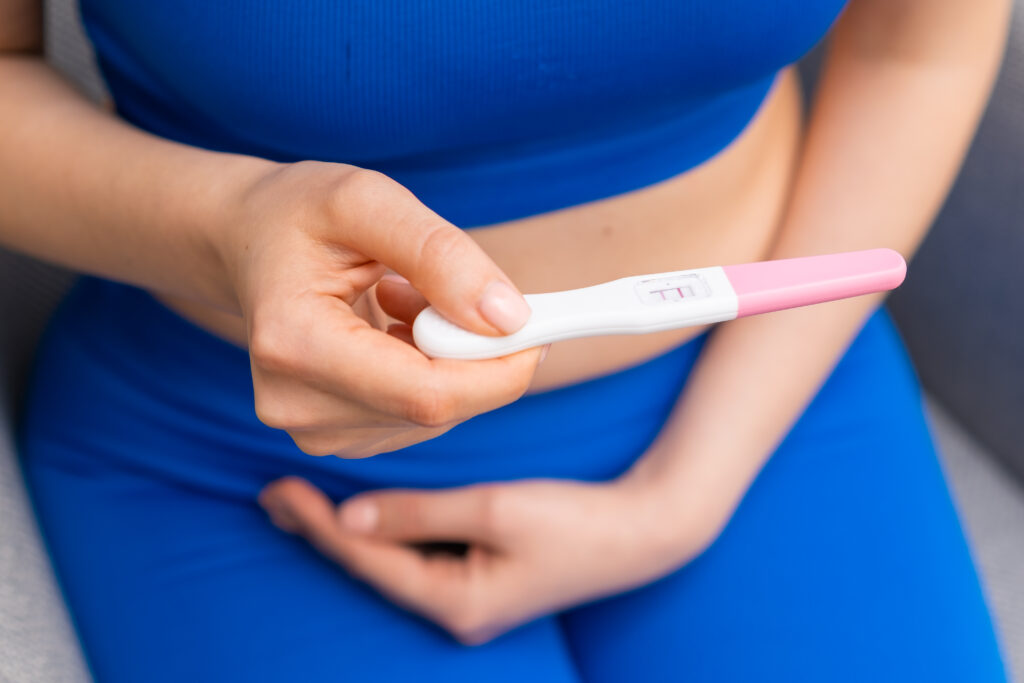 Woman holding a positive pregnancy test